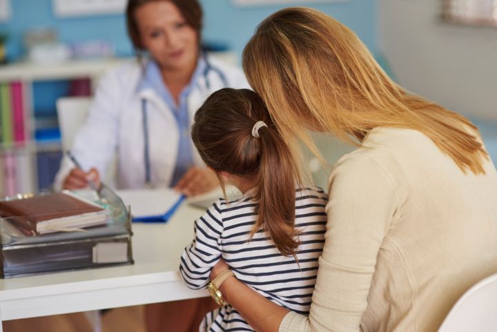 Niña y madre en la consulta del médico